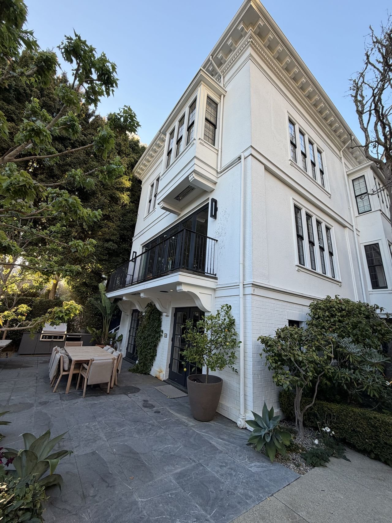 A white three-story home with rows of freshly cleaned windows