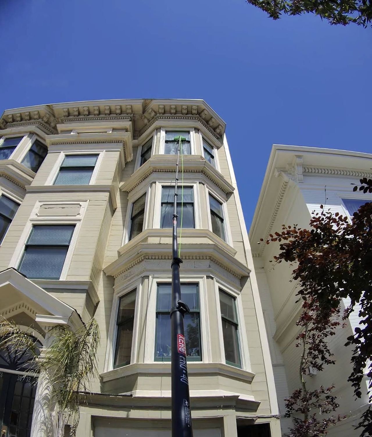 A water-fed pole reaching the top-floor windows of a San Francisco Victorian